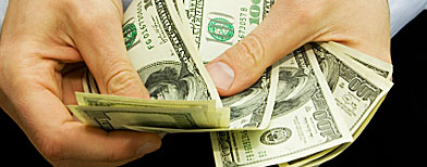 Una persona con billetes de dólar en la mano / Foto: iStockphoto