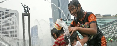 Anak-anak bermain air di kolam Bundaran HI (Foto: AP/Dita Alangkara)