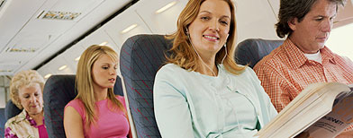 Woman relaxing on plane, smiling, portrait / Digital Vision