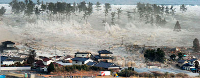 Waves from a tsunami hit residences after a powerful earthquake in Natori, Miyagi prefecture (state), Japan, Friday, March 11, 2011. The largest earthquake in Japan's recorded history slammed the eastern coast Friday. (AP Photo/Kyodo News)