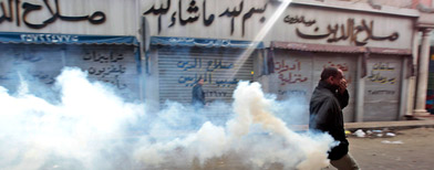 An Egyptian anti-government activist runs to throw back a tear gas canister fired by riot police officers during clashes in Cairo, Egypt, Friday, Jan. 28, 2011 (AP Photo/Lefteris Pitarakis)