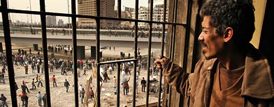 A man looks down from the window of a derelict house as anti-government protestors man barricades in Tahrir Square.  (Photo by Peter Macdiarmid/Getty Images)