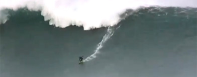 Surfer rides huge wave (GrindTV.com)