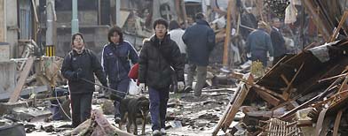 Residents walk through urban area devastated by tsunami in Natori, Miyagi, northern Japan, Saturday, March 12, 2011. (AP Photo/Kyodo News)