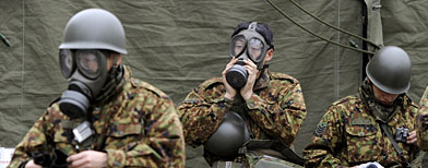Japanese soldiers don gasmasks and protective gear. (Foto AP/Kyodo News)