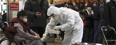 A woman on a wheelchair takes a radiation exposure scanning at a gymnasium in Koriyama, northern Japan, Wednesday, March 16, 2011. (The Yomiuri Shimbun, Koichi Nakamura/AP Photo)