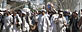 Protestors walk with sticks, as they carry a wounded colleague during a demonstration to condemn the burning of a copy of the Muslim holy book by a Florida pastor, in Kandahar, Afghanistan on Saturday, April 2, 2011. (AP Photo/Allauddin Khan)