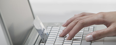 person on laptop with credit card (Corbis)