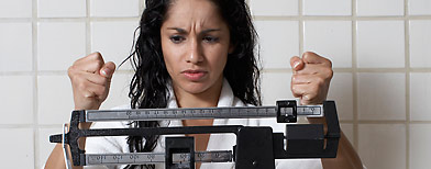 Frustrated woman looking at scale (Thinkstock)