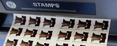 A United States Postal Service employee purchases Forever stamps.  (AP Photo/Kathy Willens)