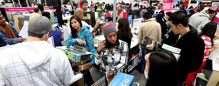 Customers shop for electronics (Photo by Sandy Huffaker/Getty Images)