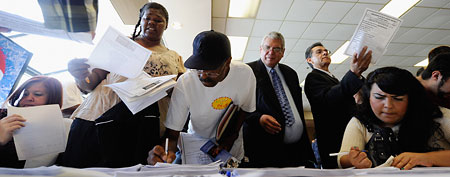 Vincent Gonzales, (2nd-R) who had been laid off for the past two-years, along with other job seekers, register and pick up open jobs fliers from potential employers at Los Angeles Mission's 10th annual Skid Row Career Fair June 2, 2011 in Los Angeles. (Photo by Kevork Djansezian/Getty Images)