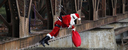 A firefighter dressed as Santa Claus rappels off a bridge in Guatemala City (Jorge Dan Lopez/Reuters)