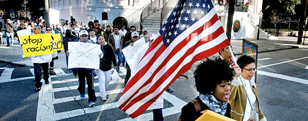 Jheanelle Wilkins, front left, with The Leadership Conference Education Fund, and Diana Salazar, with the South Carolina Immigration Coalition, lead a protest march against South Carolina law SB 20 to the Charleston Federal Courthouse, where a hearing on the constitutionality of the law was being held Monday morning, Dec. 19, 2011, in Charleston, S.C. (AP Photo/The Post and Courier, Brad Nettles)