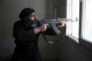 A Free Syrian Army fighter aims his AK-47 rifle through a window in Aleppo's Salaheddine neighbourhood