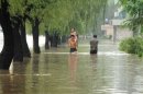 People walk down a flooded road in Anju city in North Korea's South Phongan province