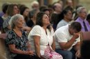The grandmother, left, mother, and father of Aurora movie theater shooting victim Micayla Medek mourn during a memorial mass held for families and supporters of those killed, at St. Michael the Archangel Catholic Church, in Aurora, Colo., on Friday July 19, 2013. Saturday, July 20 marks one year since the Aurora movie theater shooting rampage, which left 12 dead and 70 wounded. (AP Photo/Brennan Linsley)