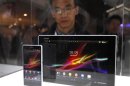 A visitor looks at the new Sony Xperia Z phone and tablet through a glass window during the Mobile World Congress in Barcelona