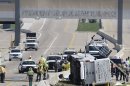 A charter bus rests on it's side after crashing on the President George Bush Turnpike Thursday, April 11, 2013, in Irving, Texas. The chartered bus overturned on the busy highway near Dallas killing at least two people and injuring several others, authorities said. (AP Photo/LM Otero)