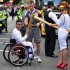 In this Saturday, July 21, 2012,  photo provided by LOCOG, singer Paloma Faith passes the Olympic Flame to torchbearer  Sheikh Sheikh on the Torch Relay leg through London. The opening ceremonies of the Olympic Games are scheduled for Friday, July 27. (AP Photo/LOCOG, Ben Birchall)