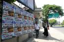 Sri Lankan pedestrians walk past a poster thanking nations which supported Sri Lanka at the UN Human Rights Council where a US-led resolution calling for a war crimes probe against the island was adopted, in Colombo on March 30, 2014