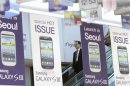 A man standing passes Samsung Electronics' new Galaxy S III smartphone advertisement boards at a Samsung Electronics store in Seoul