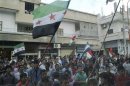 Demonstrators hold Syrian opposition and Kurdish flags during a protest against Syria's President Bashar al-Assad in Qubani
