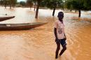 A young boy walks a flooded street on September 5, 2013 in a district in Niamey