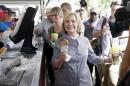 Democratic presidential candidate Hillary Rodham Clinton leaves a pork chop stand during a visit to the Iowa State Fair, Saturday, Aug. 15, 2015, in Des Moines, Iowa. (AP Photo/Charlie Neibergall)