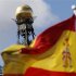 A Spanish flag flutters in the wind in front of the dome of Bank of Spain headquarters in central Madrid