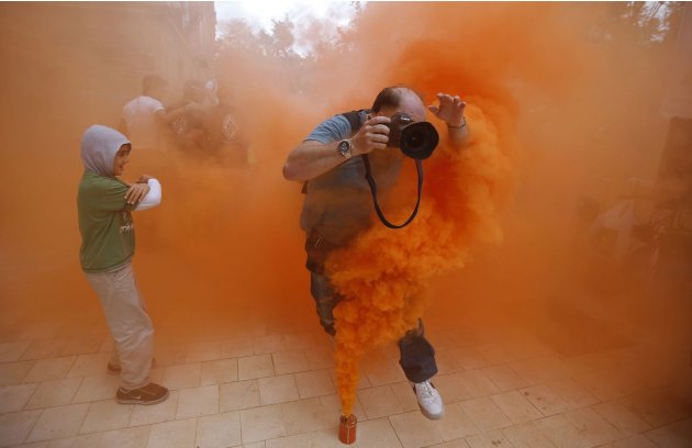مصور يقفز فوق قنبلة غاز مسيل للدموع خلال احتجاجات في مدينة سيفيليا الأندلسية