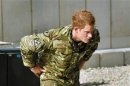 Britain's Prince Harry examines the 30mm cannon of an Apache helicopter at Camp Bastion, Afghanistan