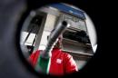 FILE PHOTO: A man points a fuel nozzle at the camera for a photograph at a gas station belonging to Venezuelan state oil company PDVSA in Caracas