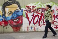 A woman walks past a mural depicting Venezuelan President Hugo Chavez in Caracas January 9, 2013. Chavez's formal swearing-in for a new six-year term scheduled for January 10 can be postponed if he is unable to attend due to his battle to recover from cancer surgery, Venezuela's vice president Nicolas Maduro said. Maduro's comments were the clearest indication yet that the Venezuelan government is preparing to delay the swearing-in while avoiding naming a replacement for Chavez or calling a new election in the South American OPEC nation. REUTERS/Carlos Garcia Rawlins