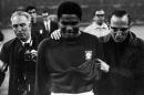 FILE - In this July 26, 1966 file photo, Portugal's star player Eusebio is led from the pitch in tears after England defeated Portugal 2-1 in the semifinal of the World Cup at Wembley, London. Eusebio, the Portuguese football star who was born into poverty in Africa but became an international sporting icon and was voted one of the 10 best players of all time, has died of heart failure aged 71, Sunday, Jan. 5, 2014. (AP Photo/Bippa, File)