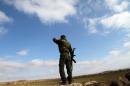 A Syrian soldier looks out from his position in the southern city of Sweida on January 23, 2013