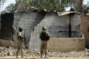 Soldiers looks at burnt houses in the village of Dalori, some 12 kilometres from Borno state capital Maiduguri, northeastern Nigeria, after an attack by Boko Haram insurgents left at least 85 dead