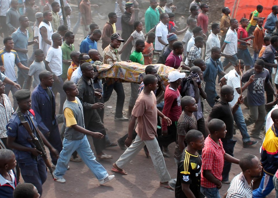 Residents carry the body of a person killed hours earlier when a rocket struck a home, as they take to the streets in protest over recent violence, in Goma, Congo, Saturday, Aug. 24, 2013. Congolese soldiers supported by U.N. forces fought rebels in the country's deteriorating east for hours early Saturday, officials said, while a rocket landed inside the town of Goma. Congo immediately blamed the attacks on neighboring Rwanda, which has long been accused of supporting the eastern Congolese rebel movement known as M23. (AP Photo/Alain Wandimoyi)