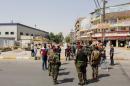 Iraqi security forces gather at the site of a suicide bomb blast in Baghdad al-Jadida