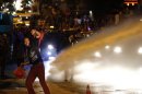 An anti-government protester throws stones as they clash with riot police in central Ankara