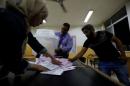 Officials count ballots after polls closed at a polling station for parliamentary elections in Amman