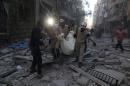 Syrian emergency personnel carry a body following an air strike on November 3, 2015, in the rebel-held side of the northern city of Aleppo