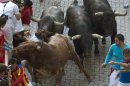 An unidentified 23-year-old Australian woman falls in between bulls after getting gored by a Miura fighting bull during the last running of the bulls of the San Fermin festival in Pamplona