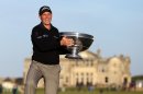 English golfer David Howell poses on the Swilcan Bridge with the trophy after winning the The Alfred Dunhill Links Championships golf competition on The Old Course at St Andrews, Fife, Scotland on September 29, 2013