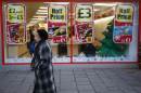 A woman walks past a discount food store on December 5, 2012 in London, England