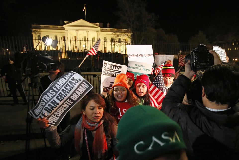 FILE - In this Nov. 20, 2014 file photo, people chant during a demonstration in front of the White House in Washington as President Barack Obama...