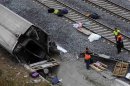 Rescue workers stand amongst the wreckage of a train crash near Santiago de Compostela