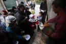 Syrians receive food aid from a community kitchen that caters to impoverished families in the Myassar neighbourhood of Aleppo on November 23, 2014