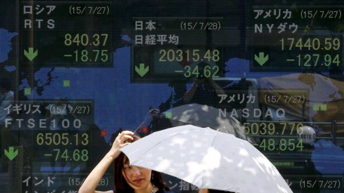 Women stand in front of board showing market indices in Tokyo