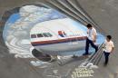Students walk past a mural featuring missing Malaysia Airlines flight MH370 on the grounds of their school in Manila on March 18, 2014